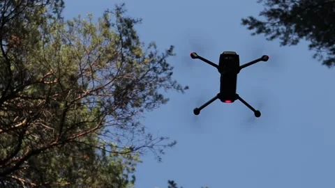Drone hovering in the air with forest background Stock Footage 134338143