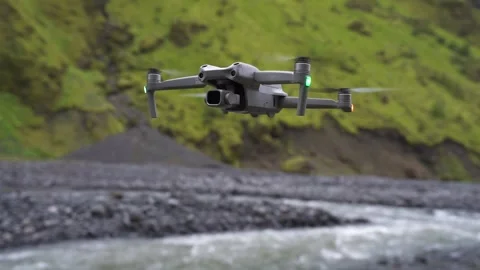 Drone Hovering In Air Outdoors in Nature River Grass Covered Mountain Stock Footage 258487166
