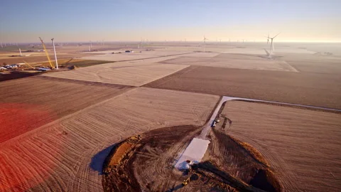 Drone hovering and circling active wind turbine build site Video stock 329222991