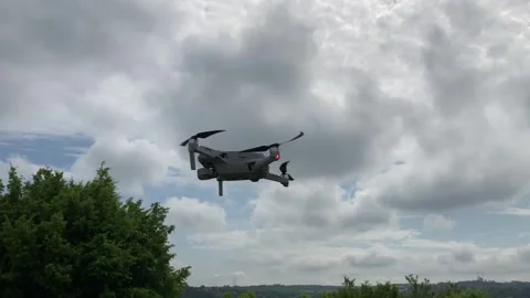 Drone Hovering in a Cloudy Sky Over Trees Stock Footage 301403735