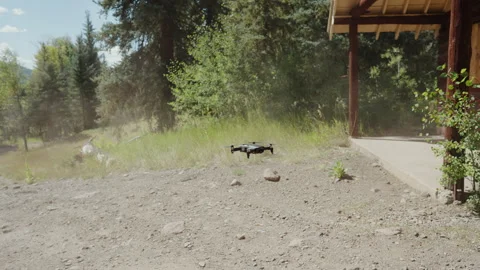 Drone hovering low over dirt yard beside log cabin Video stock 348021270