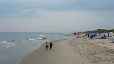 Drone hovering over a beach with people enjoying their morning Stock Footage 342430312
