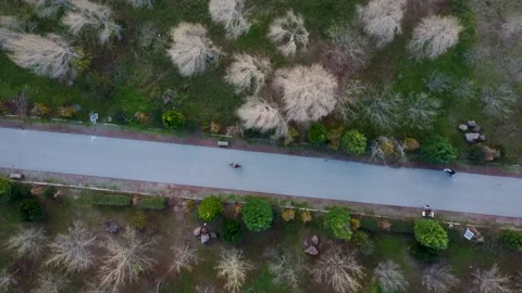 Drone hovering over a pathway with people cycling at a park in turkey 動画素材 224665696