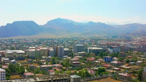 Drone hovers above central Dogubayazit with surrounding mountains, low rise Vídeo Stock 344835633
