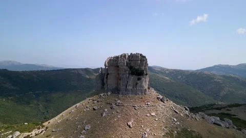 Drone hovers around the green Monte Perda Liana in Italy between a hilly Stock Footage 147408189