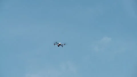 The drone hovers in the background of a blue sky and suddenly flies out of t Stockbeeldmateriaal 336845977