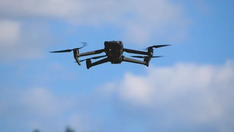 A drone hovers in a clear blue sky. Stock Footage 312918602