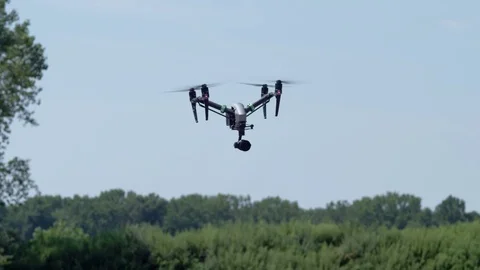 Drone hovers in front of trees.  Exits shot over camera Stock Footage 80151911