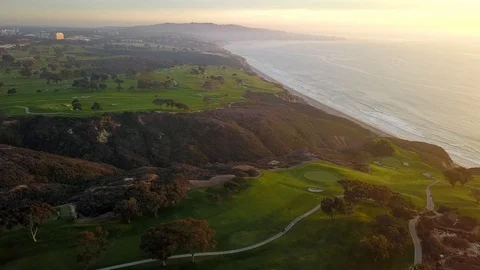 Drone hovers over golf course on cliffs over ocean near sunset in San Diego Stock Footage 97859103