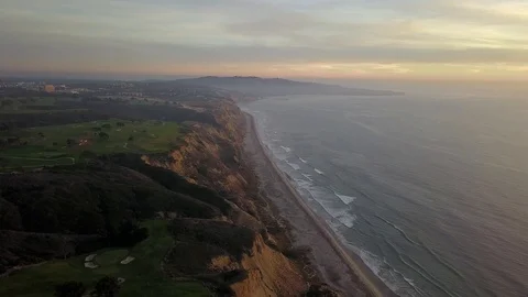 Drone hovers over golf course on cliffs over ocean near sunset in San Diego Stock Footage 97859115