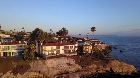 Drone hovers over reefs viewing oceanfront mansions with La Jolla background Stock Footage 97185092