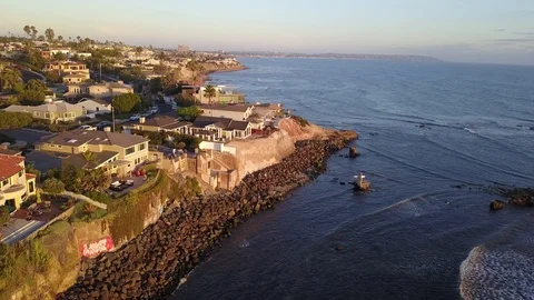 Drone hovers over reefs viewing oceanfront mansions with La Jolla background Stock Footage 97185161