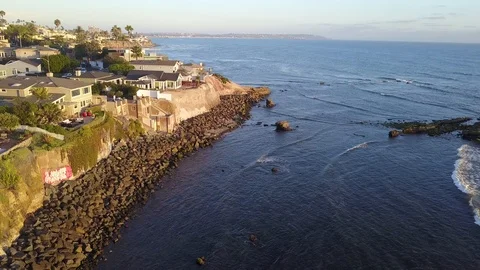 Drone hovers over reefs viewing oceanfront mansions with La Jolla background Stock Footage 97185808