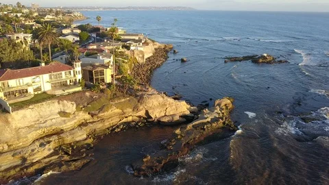 Drone hovers over reefs viewing oceanfront mansions with La Jolla background Stock Footage 97185823