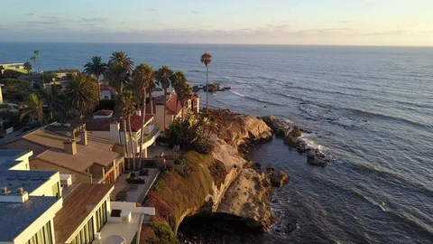 Drone hovers over reefs viewing oceanfront mansions with La Jolla background Stock Footage 97186121