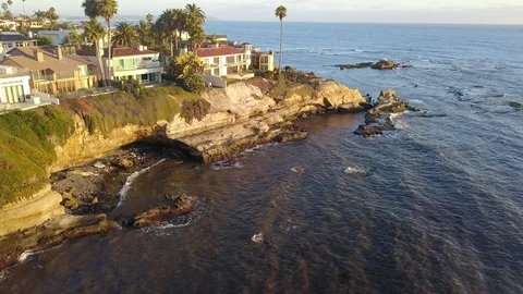 Drone hovers over reefs viewing oceanfront mansions with La Jolla background Stock Footage 97201217