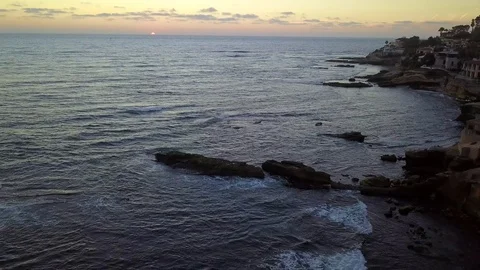 Drone hovers over reefs viewing oceanfront mansions at sunset Stock Footage 97201239