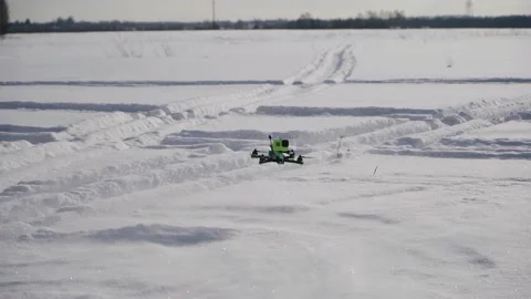 The drone hovers over the snow, lifting it into the air by the air pressure Stock Footage 169928734