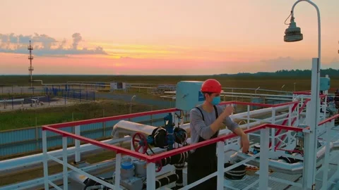 The drone hovers over a worker in a helmet and a mask who is standing on a Stock-Footage 167937929