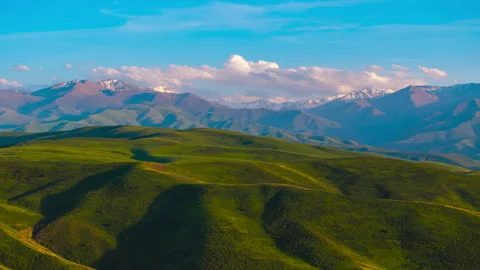 Drone hyperlapse above green foothills in Kyrgyzstan Stock Footage 344286725