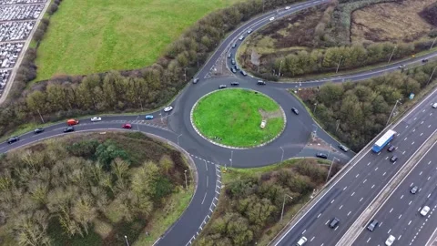 Drone hyperlapse circles M25 junction as traffic and lorries stream past Stock Footage 327450043