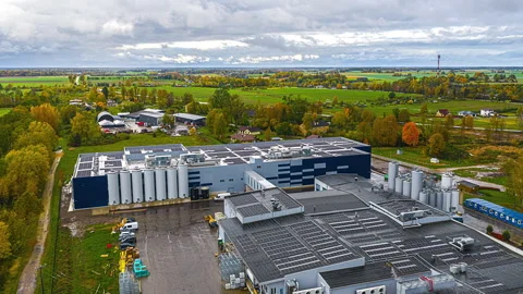 Drone hyperlapse over a large factory with rooftop solar panels and storage Stock Footage 331655315