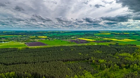 Drone hyperlapse of patchwork farmland and forest under shifting dramatic sky Stock Footage 313870500