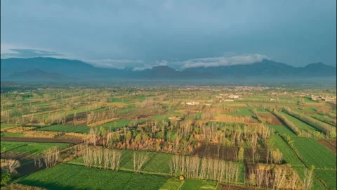 Drone Hyperlapse of Sunlight Emerging from Clouds over a Agricultural Valley, Stock Footage 332600316