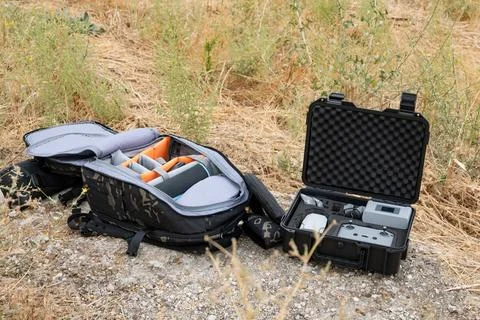 Drone inside a protective case and backpack lying on the ground Stock Photos