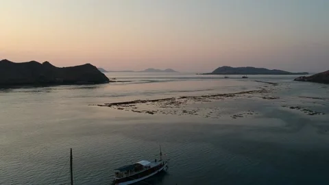 Drone, Komodo, diving boat at sunset with islands in the background Stock Footage 130314016