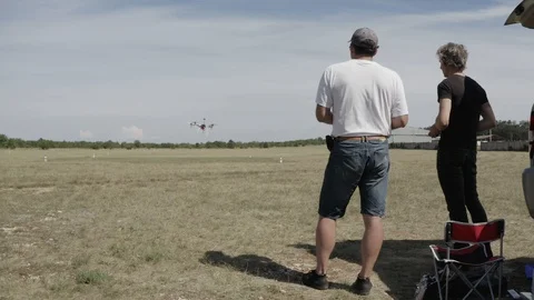 Drone landing during drone license practice, instructor and operator back view Stock Footage 112631083
