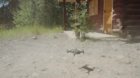 Drone landing in dust cloud outside log cabin Stock-Footage 348021359