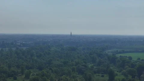 Drone lateral slide toward Cremona skyline with Torrazzo above the Po Valley Stock Footage 340604188