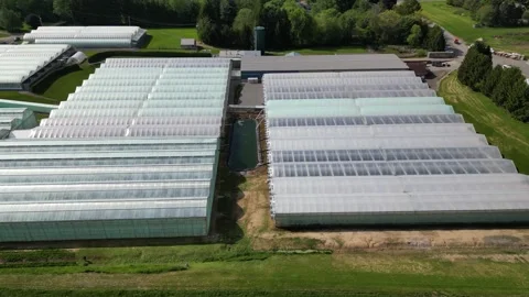 Drone - Left to Right Slight Rise  of Greenhouses &amp; Distant Towns Stock Footage 314228190