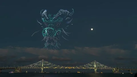 Drone light show forming abstract shapes over gwangan bridge in busan 库存影片 343066254