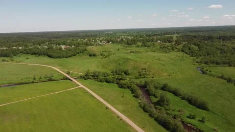 Drone a Long Flight over a Rural Road Stream Hill Fort and Village Stock Footage 134144965