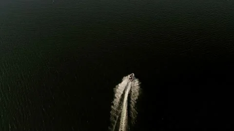 Drone looking down on pleasure craft as it swerves on the water Stock Footage 134300355