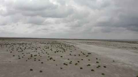 Drone low angle backward shot of desert dry salt lake in cloudy day Stock Footage 123953473