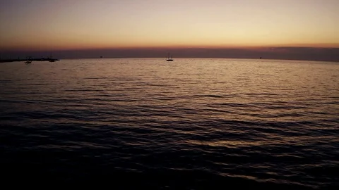 Drone low flight over the sea and over a sailboat during the sunrise Stock Footage 120584267