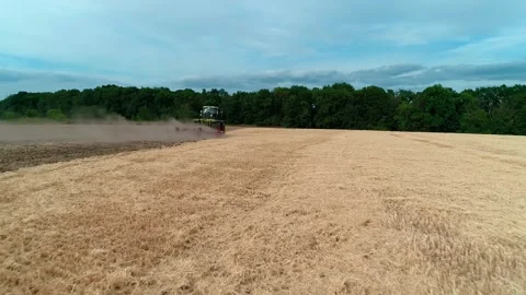 Drone low flight view of a tractor plows the land after harvesting wheat. Top 스톡 동영상 248049748