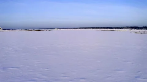 The drone low flying at high speed over the ice of a frozen lake. Aerial View Stock Footage 147507610