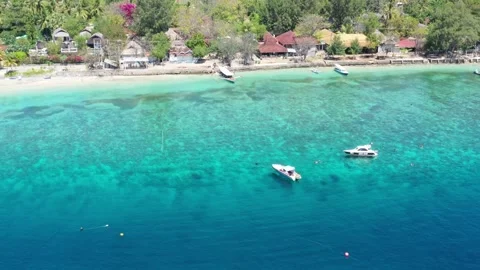 Drone low over clear water with two boats off Gili Trawangan Видео 344986512
