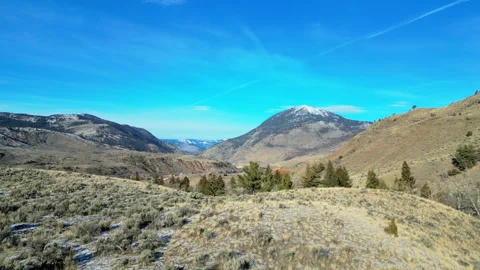 Drone low over snowy sage brush with mountains Stock Footage 326349744