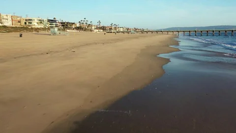 Drone low over waves and up to empty CA beach during pandemic Video stock 127610216
