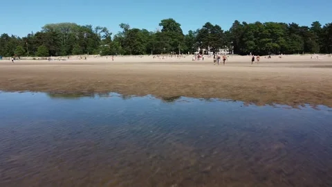 Drone low Tide on the Beach People Walking and playing Sports in the Woods V Stock Footage 134285033