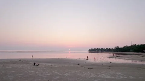 Drone at low tide at sunset. Everything is pink, purple sky people on beach Stock Footage 278310144