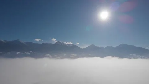 Drone lower into clouds with mountains in winter Stock Footage 310527081