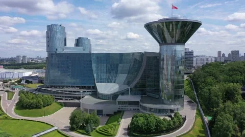 Drone lowering and tilting up in front of glass building Stockbeeldmateriaal 329212849