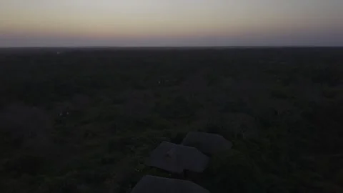Drone lowers from high over restaurant and lodge on hill after sunset Stock Footage 344172364