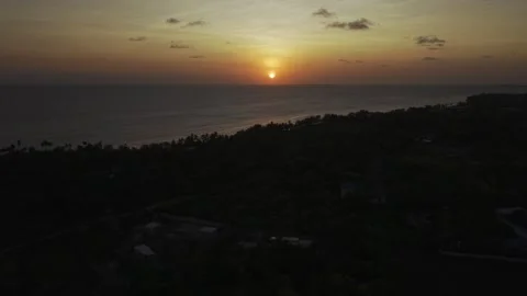 Drone lowers over forest with view of sunset on the horizon on the sea Stock-Footage 346159046